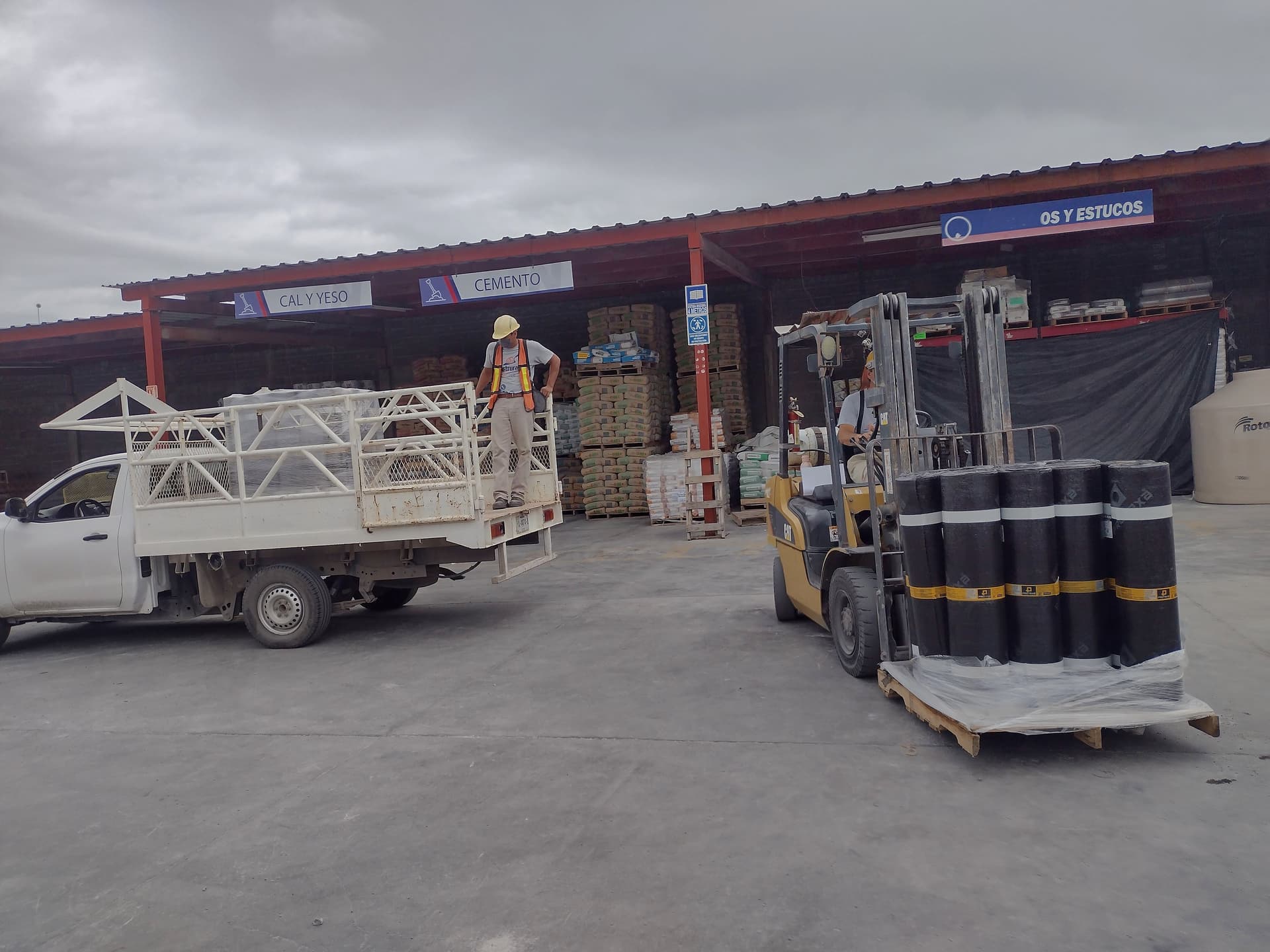 Montacargas cargando rollos de membrana prefabricada en camioneta de trabajo